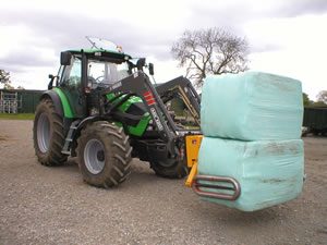 Tractor carrying wrapped haylage bales